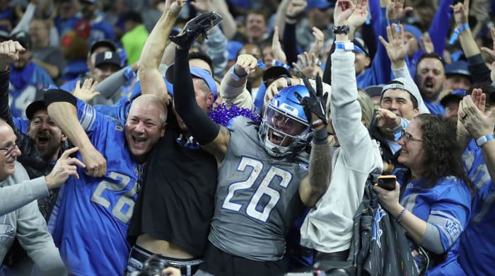 Jahmyr Gibbs celebrates amid Lions fans after scoring a touchdown